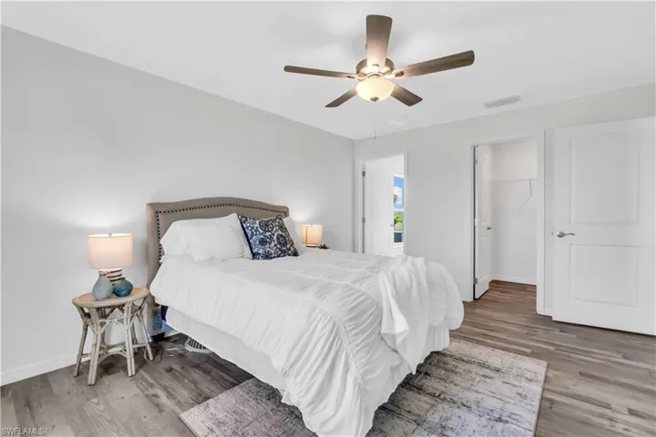 Bedroom with baseboards, visible vents, and wood finished floors