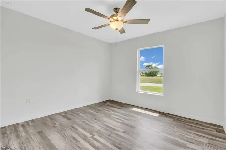 Empty room featuring baseboards, ceiling fan, and wood finished floors