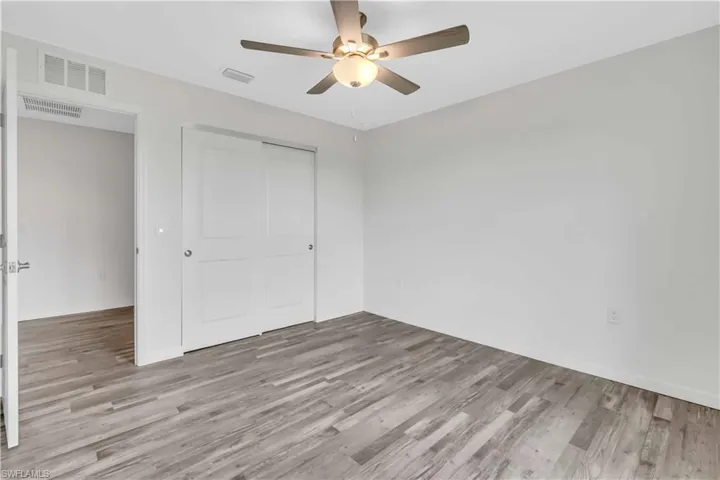 Unfurnished bedroom with wood finished floors, a closet, and visible vents