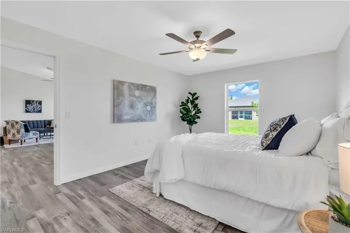 Bedroom with baseboards, ceiling fan, and wood finished floors