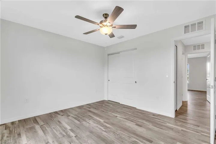 Unfurnished bedroom featuring baseboards, visible vents, a closet, and light wood-type flooring
