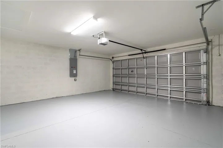 Garage featuring electric panel and a garage door opener