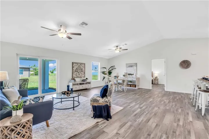 Living area with visible vents, a wealth of natural light, and ceiling fan