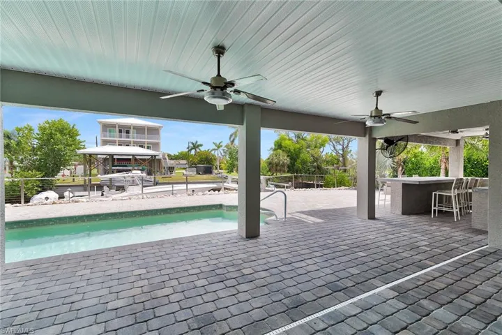 View of patio / terrace featuring a ceiling fan and an outdoor pool