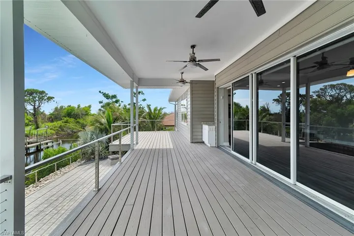 Wooden deck featuring ceiling fan and a water view