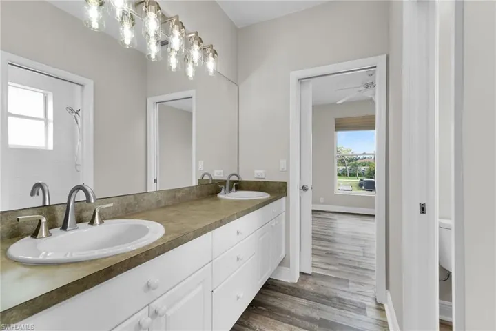 Bathroom featuring double vanity and wood finished floors