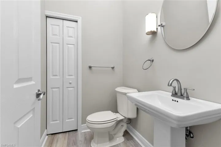 Half bath featuring a closet and wood finished floors