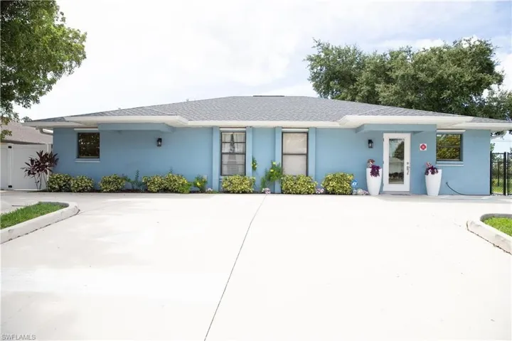 Light blue stucco exterior with a dark shingle roof