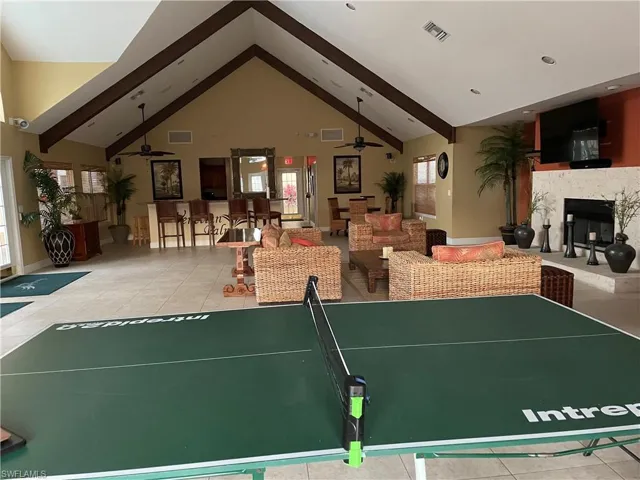 Recreation room with a fireplace and a ceiling fan