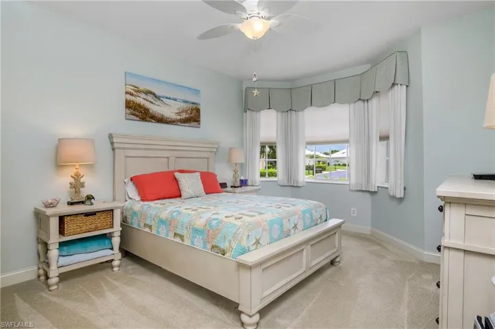 Carpeted bedroom featuring ceiling fan