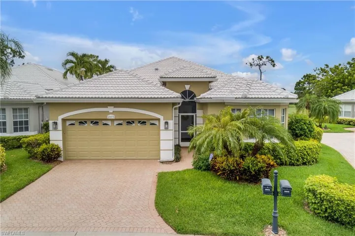 View of front of property with a garage and a front lawn