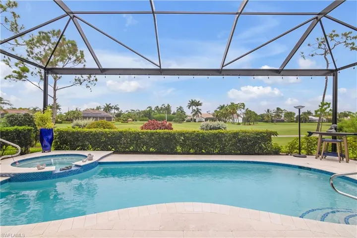 View of swimming pool with an in ground hot tub and a lanai