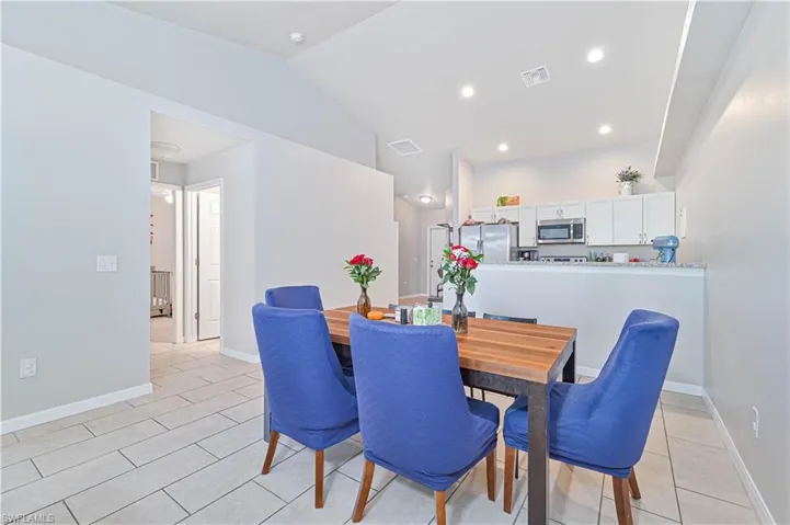 Dining space featuring light tile patterned floors and lofted ceiling