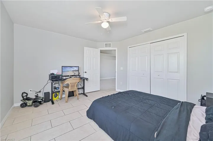 Bedroom featuring light tile patterned floors, a closet, and ceiling fan