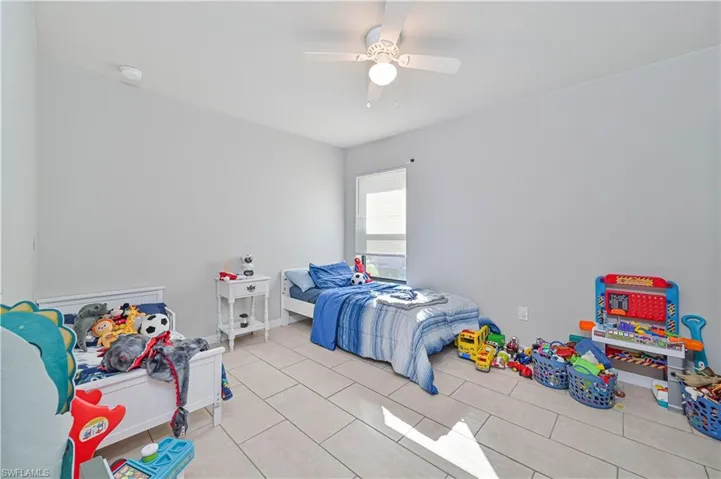 Bedroom featuring light tile patterned floors and ceiling fan