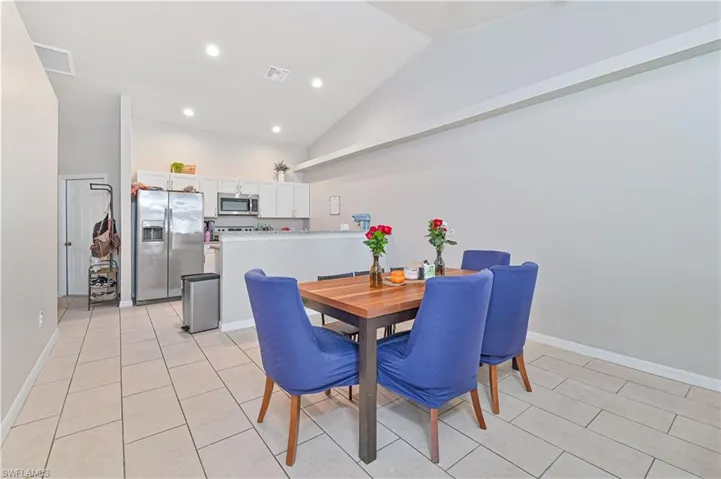 Tiled dining space with high vaulted ceiling