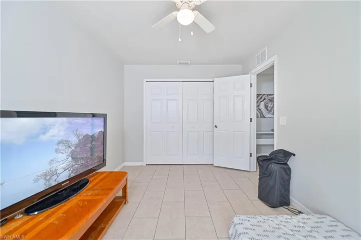 Tiled bedroom featuring a closet and ceiling fan