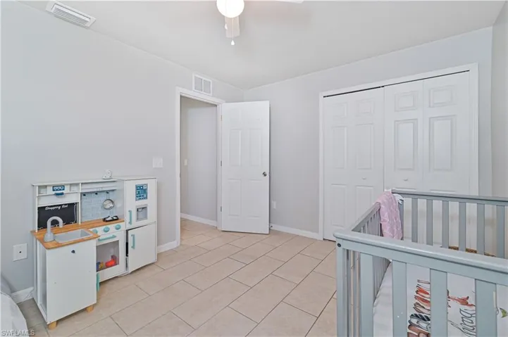 Tiled bedroom with a closet and ceiling fan