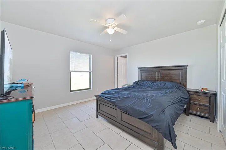 Tiled bedroom featuring ceiling fan
