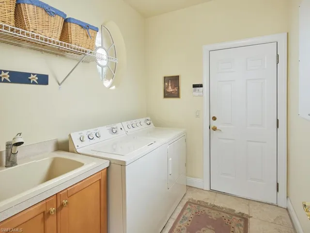 Utility room with an attractive window to the outside. Cabinets have been installed above the washer and dryer (not shown). Plenty of storage. Door leads to 2 car attached garage.
