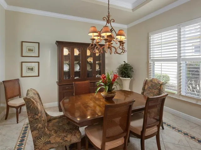 Dining room with tray ceiling, generous floor and ceiling molding and custom tile floor