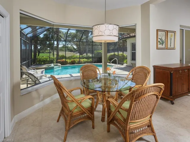 Breakfast nook dining area, new light fixture, view through mitered glass windows to lanai and golf green in distance.
