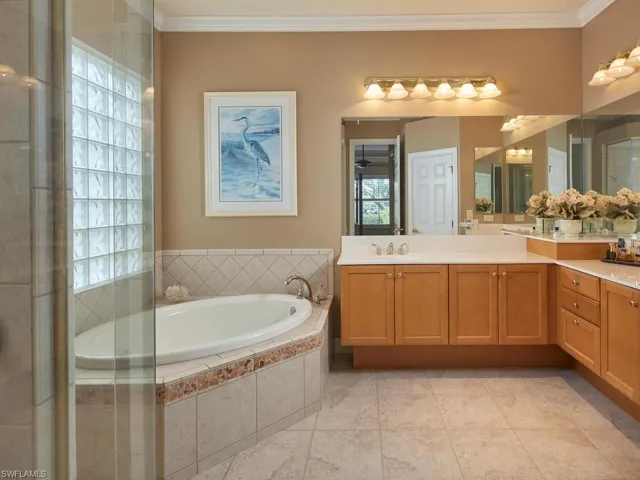 Primary bathroom with dual sinks, separate soaking tub, walk-in shower and commode.