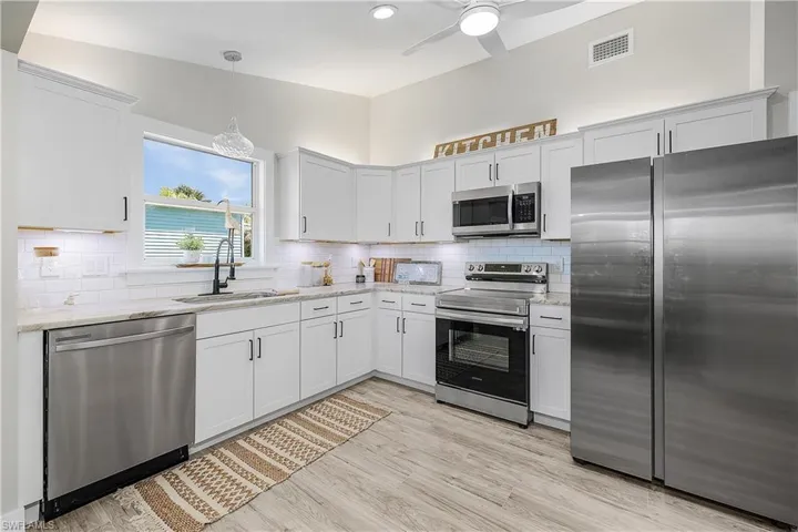Kitchen with visible vents, stainless steel appliances, decorative backsplash, and a sink