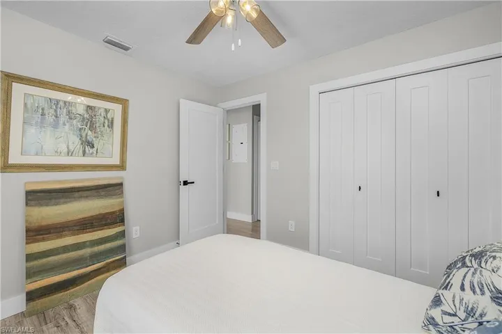 Bedroom with visible vents, wood finished floors, a closet, baseboards, and ceiling fan