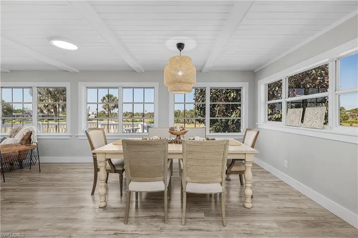 Dining space featuring beamed ceiling, baseboards, and light wood finished floors