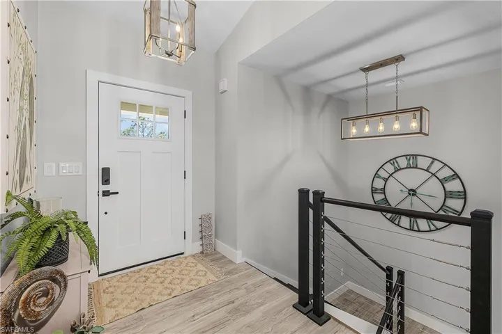 Entrance foyer with a notable chandelier, baseboards, and wood finished floors
