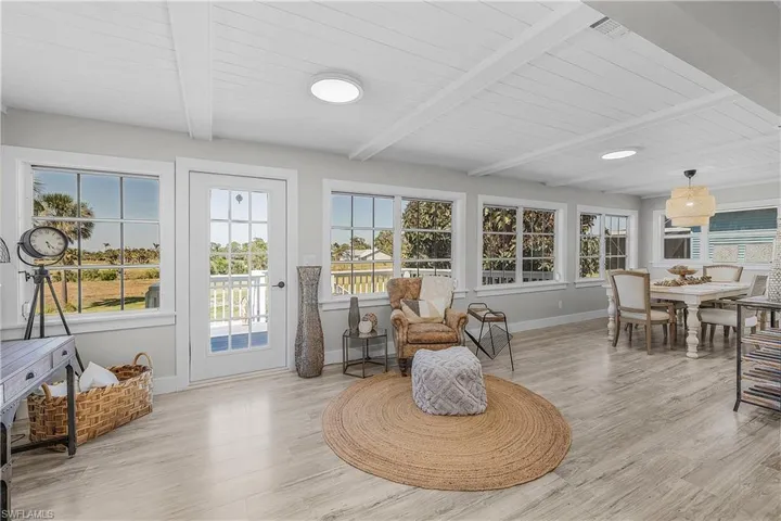 Living area with beamed ceiling, wood ceiling, baseboards, and light wood finished floors