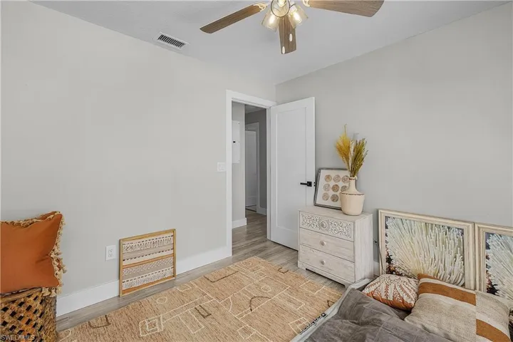 Bedroom featuring visible vents, ceiling fan, baseboards, and wood finished floors