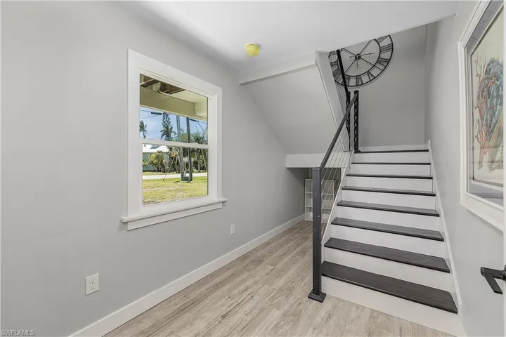 Stairway featuring wood finished floors and baseboards