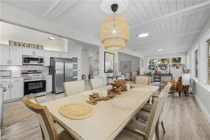 Dining space with baseboards, light wood-type flooring, beam ceiling, and wood ceiling