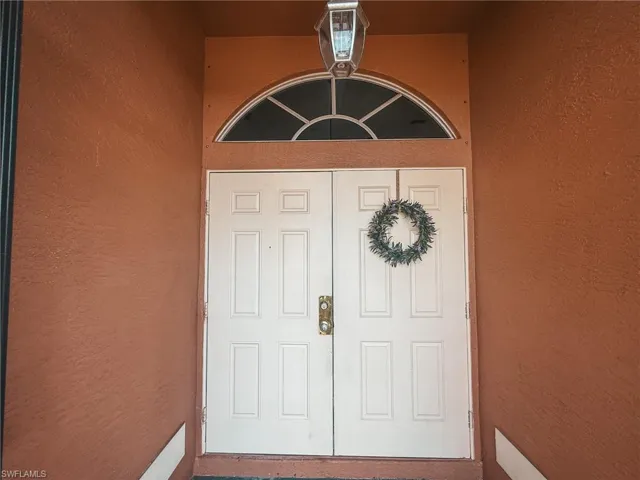 Entrance to property with stucco siding