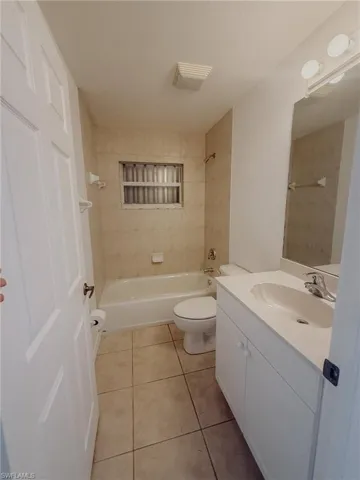Bathroom featuring vanity, tile patterned floors, toilet, shower / bathtub combination, and visible vents