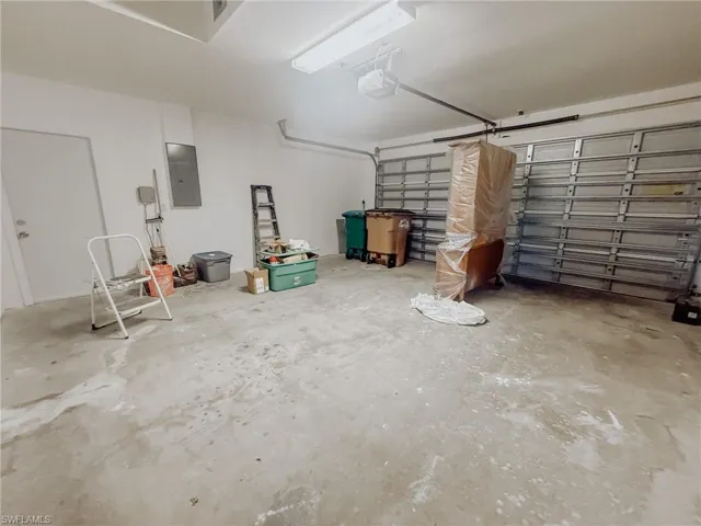 Garage featuring a garage door opener and electric panel (items do not covey)