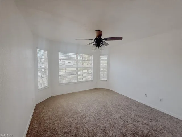 Spare bedroom with baseboards, a ceiling fan, and carpet floors