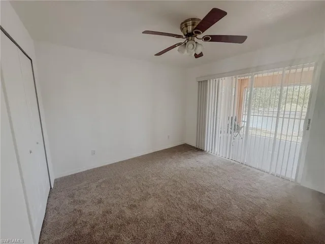 Empty room with carpet floors, baseboards, and a ceiling fan
