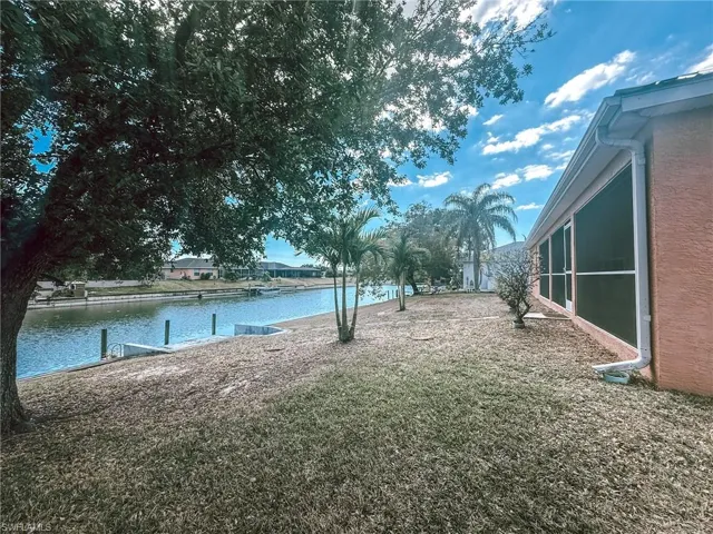 View of yard with a water view and a dock