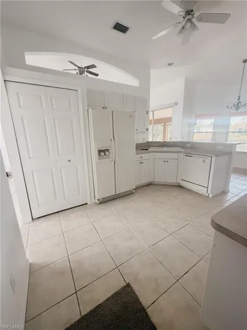 Kitchen featuring white appliances, visible vents, a sink, and a ceiling fan