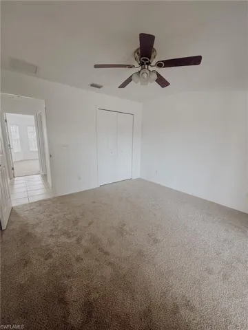Spare room featuring light colored carpet, ceiling fan, and visible vents