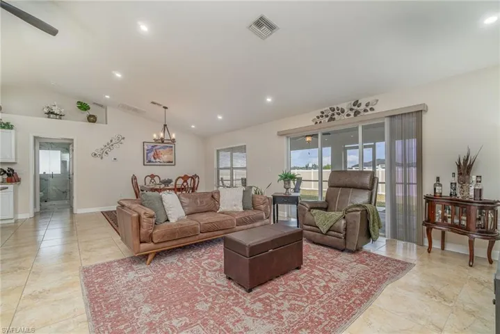 Living room featuring vaulted ceiling and dinning room chandelier