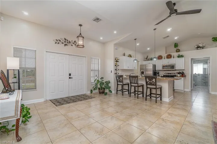 Entryway with ceiling fan and high vaulted ceiling