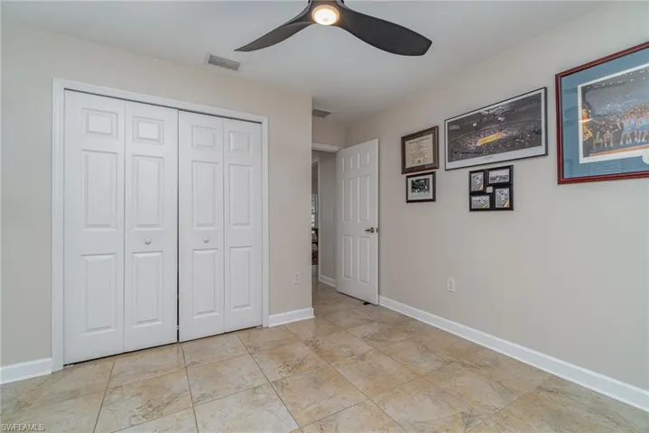 Unfurnished bedroom with ceiling fan and a closet