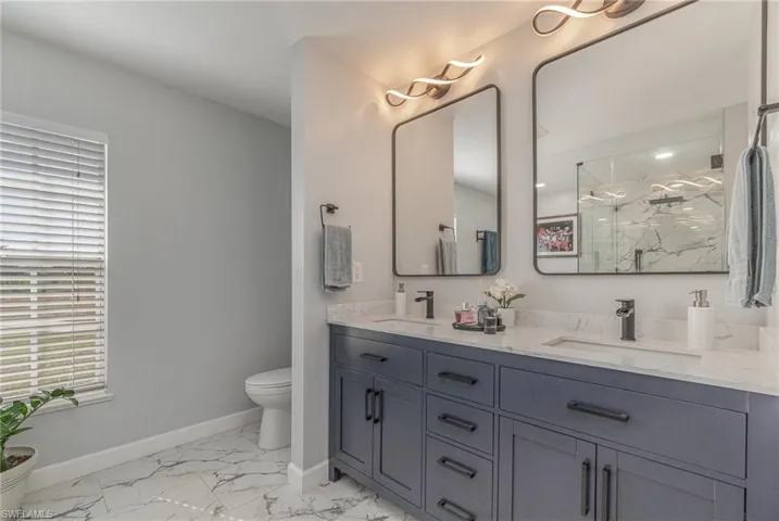 Bathroom with an enclosed shower, vanity, and toilet