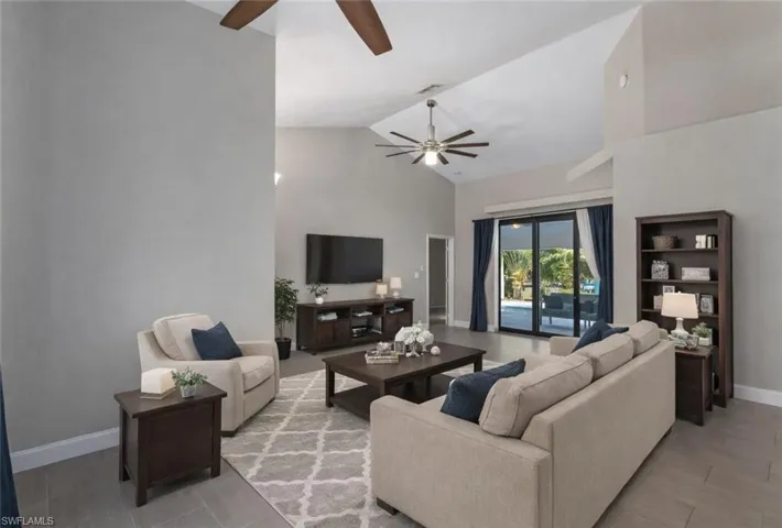 Living area featuring ceiling fan and vaulted ceiling