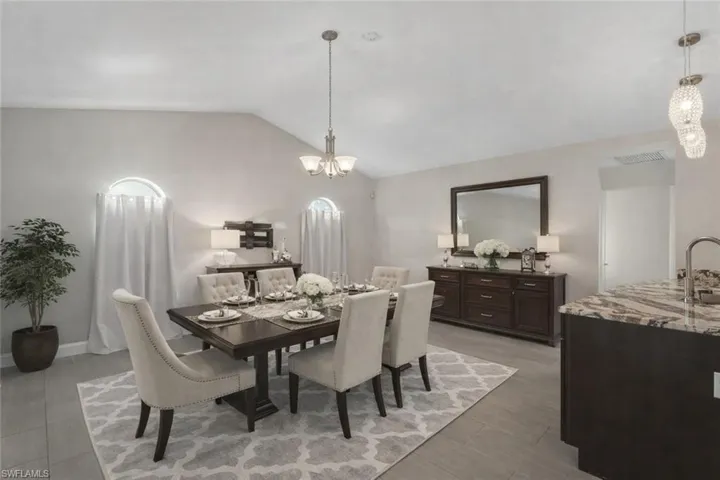 Dining space featuring suspended lighting, vaulted ceiling, and light wood-type flooring