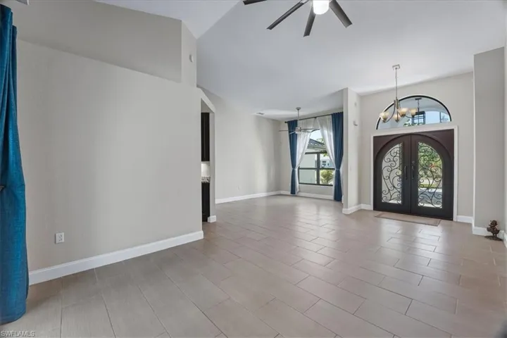 Entrance foyer featuring ceiling fan, french doors, suspended lighting, and a high ceiling